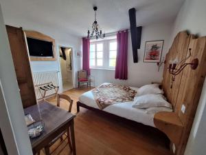 a bedroom with a bed and a table and a window at Domaine de Fondain in Laqueuille
