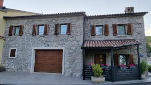 a large stone house with a brown garage at Villa Kos1 in Erkovčići +9 photos