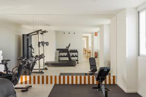 a gym with bikes and exercise equipment in a room at Almar Suites Daimús in Daimuz