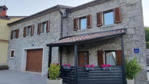 a stone house with potted plants in front of it at Villa Kos1 in Erkovčići