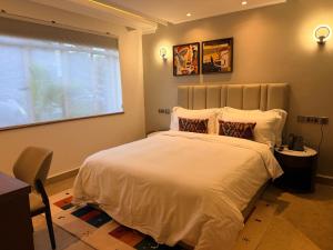 a bedroom with a large white bed with a window at Yeza Garden Hotel in Nairobi +39 photos