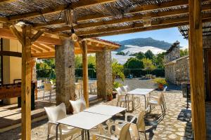 a patio with tables and chairs and a pergola at Kampaoh Fonts d' Algar in Callosa d'en Sarrià