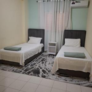 a room with two beds and a carpet at Espaço Acolhedor in Luanda