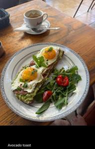 a plate of food with eggs on a table with a cup of coffee at Arvi Boutique Hotel in Lukovë