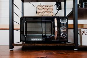 a black microwave on a shelf in a room at Creekside Village Inn in Spearfish