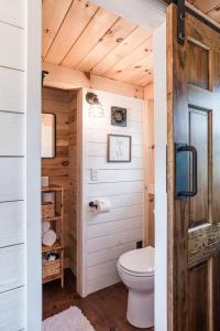 a bathroom with a toilet and a clock on the wall at Creekside Village Inn in Spearfish +146 photos
