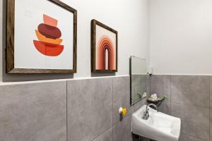 ein Badezimmer mit Waschbecken und einem Gemälde an der Wand in der Unterkunft Rincon Plaza Hotel in Rincon + 69 Fotos