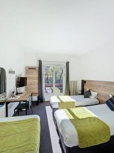 a hotel room with three beds and a desk and a window at Hôtel Lacour in Eygliers +110 photos