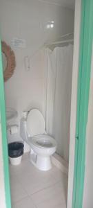 a white bathroom with a toilet and a sink at Hostal Johnnier Macao Punta Cana in Punta Cana +58 photos