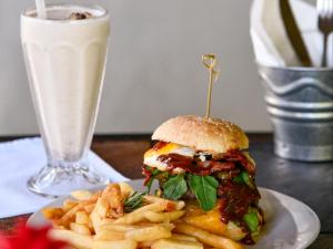 a sandwich and french fries on a plate with a drink at Mount Park Guest Farm in Dargle
