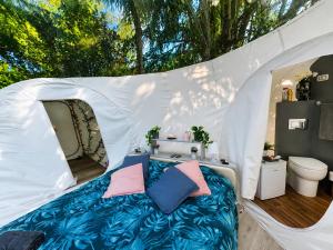 a bed in a white tent with a toilet at FUGA ROMANTICA - Panoramica in Almese