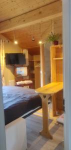 a bedroom with a bed and a table in a room at Le nid bucolique in Publier