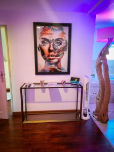 a table in a room with a painting and a statue at Domaine de la Besnerie Gites avec SPA Privatif à 10 min du Mont St Michel in Tanis