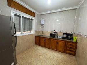 a kitchen with a sink and a microwave at Larache City Apartment in Larache