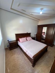 a bedroom with a bed with two pink pillows at Larache City Apartment in Larache