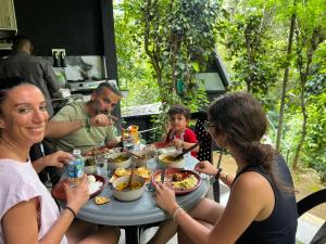 a group of people sitting around a table eating food at Pepper Trails Riverstone in Polwattekanda +41 photos