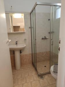 a bathroom with a glass shower and a sink at Deilino - Sunset Studio in Amorgos