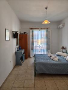 a bedroom with a bed and a television in it at Deilino - Sunset Studio in Amorgos