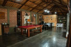 a pool table in a room with a brick wall at Hotel alamos de la puntilla in Belén