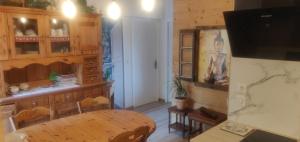 a dining room with a table and a tv at Le nid bucolique in Publier