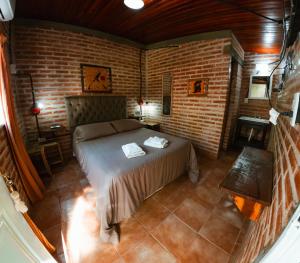 a bedroom with a bed in a brick wall at Hotel alamos de la puntilla in Belén