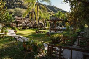 a garden with a house and a resort at Hotel alamos de la puntilla in Belén
