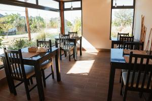 a dining room with tables and chairs and windows at Hotel alamos de la puntilla in Belén