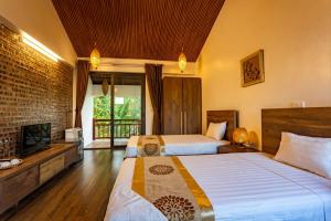 a hotel room with two beds and a television at Nan House - Tam Coc in Ninh Binh +109 photos