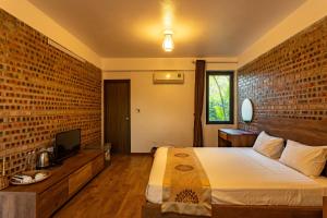 a bedroom with a bed and a brick wall at Nan House - Tam Coc in Ninh Binh