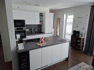a kitchen with white cabinets and a counter top at Ferienwohnung Maria - Bitburg in Stahl