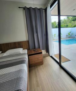 a bedroom with a bed and a large glass window at Villa La Vida Dulce Private Pool Near Playa Dorada in Puerto Plata +44 photos