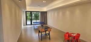 a room with a ping pong table and red chairs at Hotel Argentina in Atlántida