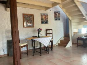 a table and chairs in a room with a staircase at Les Mialles in Prayssac