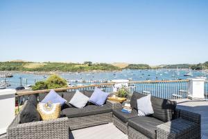 a couch on a balcony with a view of a harbor at No 21 The Salcombe in Salcombe
