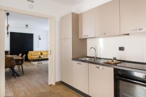 a kitchen with white cabinets and a dining room at Dimore Abruzzo - Borgo 27 in Celano