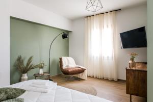 a bedroom with a bed and a chair and a television at Dimore Abruzzo - Borgo 27 in Celano
