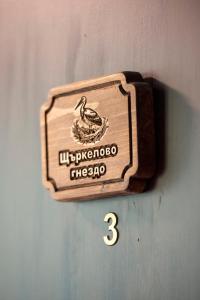 a wooden sign with a duck in a nest on a wall at The Bird Villa in Bosnek