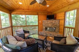 a screened in porch with chairs and a fireplace at Beary Blessed Cabin in Fleetwood