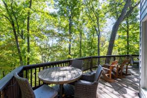 a table and chairs on a deck with trees at Beary Blessed Cabin in Fleetwood