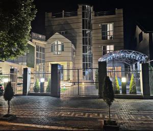 a building with a gate in front of it at night at Villa Diamond in Chişinău