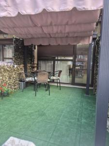 a patio with chairs and a table and awning at Studio Saturn in Saturn