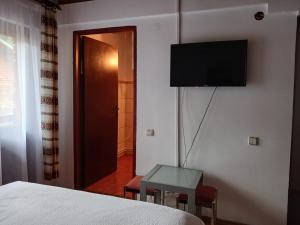 a bedroom with a bed and a tv on a wall at Gutza Family in Cumpăna