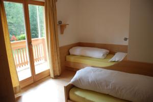 サン・マルティーノ・イン・バディーアにあるCiasa Elkeのベッドルーム1室(ベッド2台、窓付)