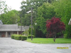 a house with a street light in front of a yard at Red Carpet Inn Brooklawn in Brooklawn