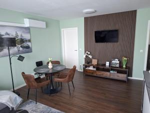 a living room with a table and chairs and a tv at Ferienwohnung Maria - Bitburg in Stahl