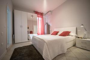 a bedroom with a white bed with red pillows at Venier Apartment in Venice