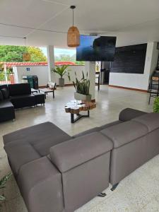 a living room with a couch and a tv at Finca Hotel Villa Alba in San Jerónimo