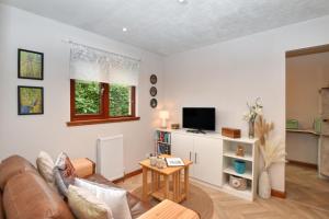 a living room with a couch and a tv at 1 Bed in Dollar oc-95872 in Powmill