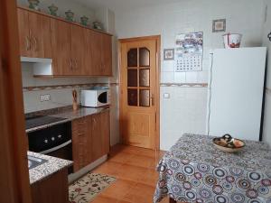 a kitchen with a table and a white refrigerator at Casa rural el cerrete in Riópar