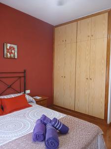 a bedroom with two purple slippers on a bed at Casa rural el cerrete in Riópar